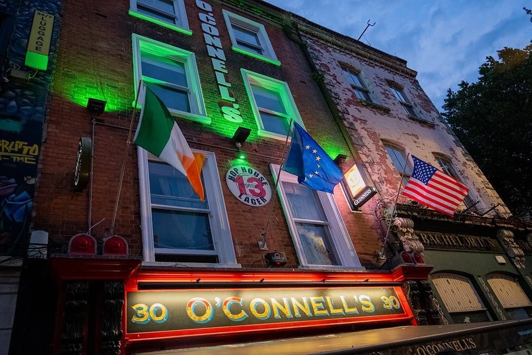 Exterior of O'Connell's Bar in Dublin with Irish and American flags at night.