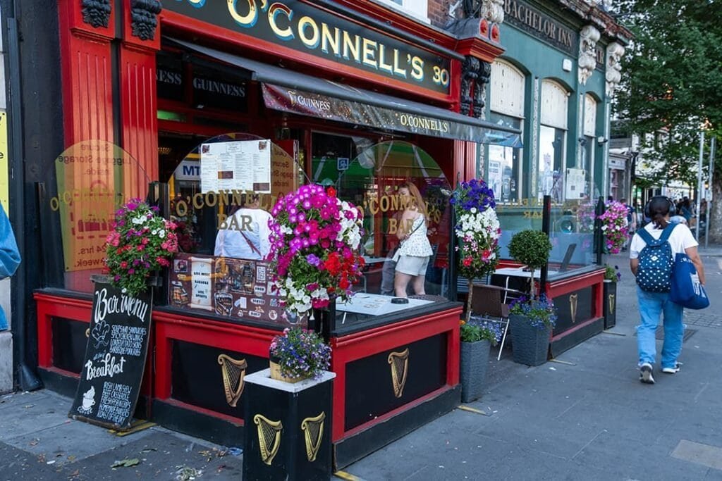 Exterior view of O'Connell's Bar in Dublin with colorful flowers and outdoor seating.