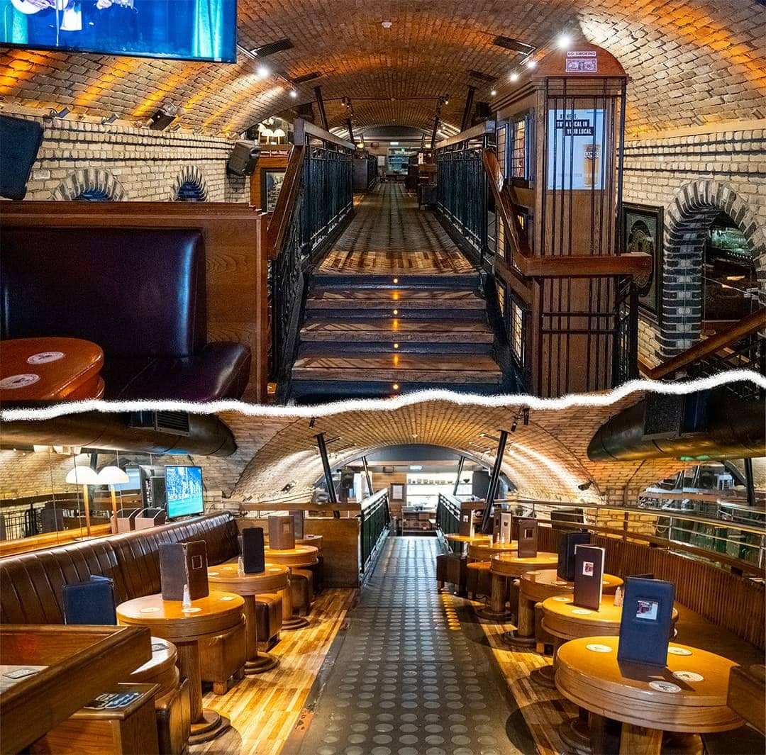 Cozy Dublin pub interior with wooden furnishings and brick arches.
